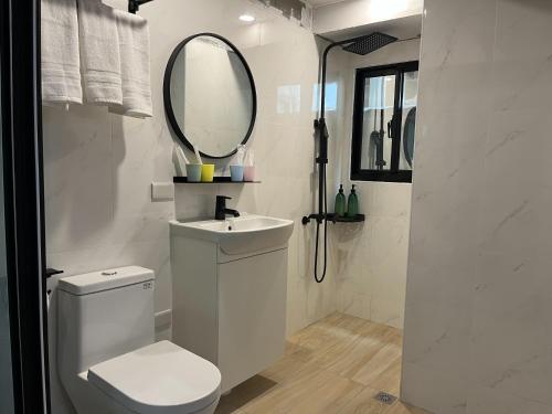 a bathroom with a toilet and a sink and a mirror at LuLu Inn in Tainan