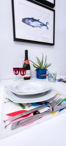 a table with plates and glasses and a bottle of wine at Apartment Gallery Zagreb in Zagreb