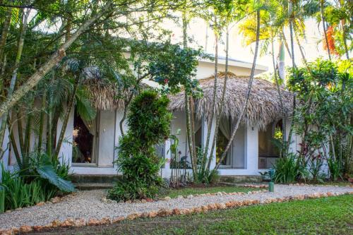 a white house with a straw roof at Hotel La Tortuga in Las Terrenas