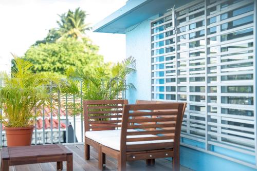 two wooden chairs sitting on a balcony with palm trees at La Esmeralda PR in San Juan