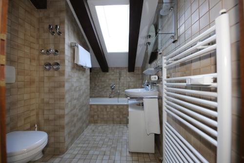 a bathroom with a toilet and a sink and a window at Ferienwohnung AlpspitzNest in Garmisch-Partenkirchen