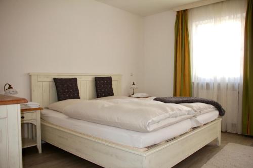 1 dormitorio con 1 cama blanca grande y ventana en Gipfeltraum en Garmisch-Partenkirchen