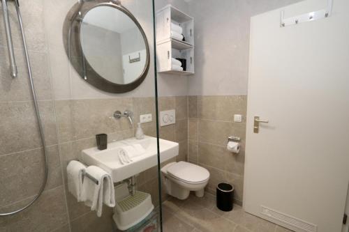 a bathroom with a sink and a toilet and a mirror at Ferienwohnung Frischluft in Garmisch-Partenkirchen