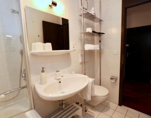 ガルミッシュ・パルテンキルヒェンにあるCentral Pearlのバスルーム(洗面台、トイレ、鏡付)