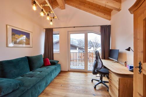 een woonkamer met een bank en een bureau met een computer bij Chalet Wild in Garmisch-Partenkirchen