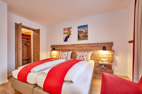 ガルミッシュ・パルテンキルヒェンにあるFelsenfestのベッドルーム1室(大型ベッド1台、赤い椅子付)