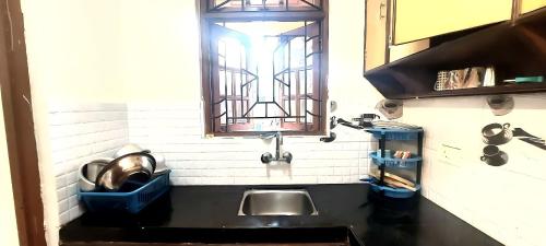 uma cozinha com um lavatório e uma janela por cima em Casa Cottage Benaulim em Benaulim