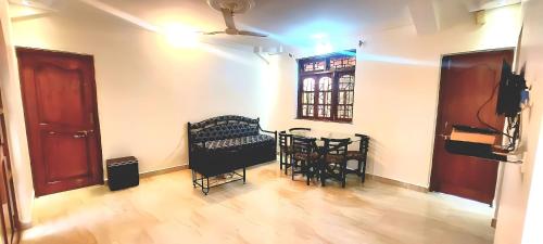 um quarto com uma mesa e cadeiras e uma janela em Casa Cottage Benaulim em Benaulim