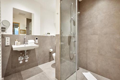 uma casa de banho com um chuveiro e um lavatório. em BergJuwel em Garmisch-Partenkirchen