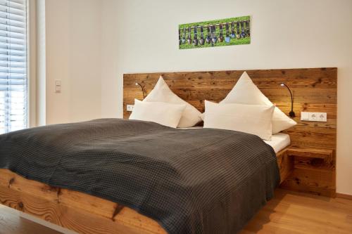 een slaapkamer met een groot bed met een houten hoofdeinde bij Gams in Garmisch-Partenkirchen