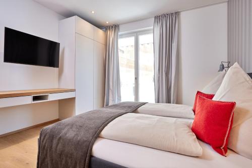 - une chambre avec un grand lit et un oreiller rouge dans l'établissement Huettenzauber, à Garmisch-Partenkirchen