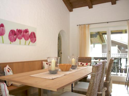 uma sala de jantar com uma mesa de madeira e flores na parede em Ferienwohnung Zugspitze em Garmisch-Partenkirchen