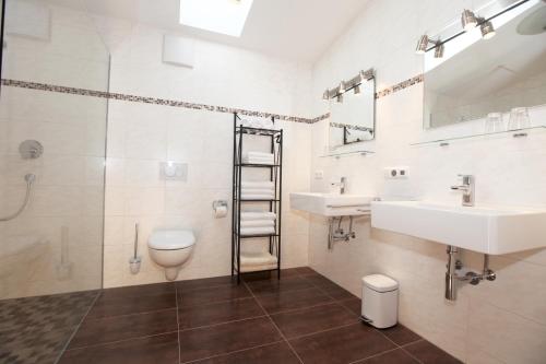 uma casa de banho com um WC, 2 lavatórios e um chuveiro em Ferienwohnung Zugspitze em Garmisch-Partenkirchen