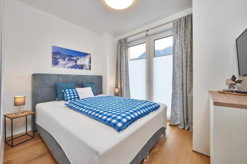 um quarto com uma cama grande e uma janela em BergZeit em Garmisch-Partenkirchen