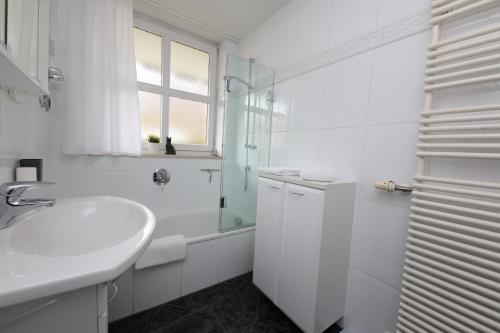 ガルミッシュ・パルテンキルヒェンにあるFerienwohnung Jolienの白いバスルーム(シンク、シャワー付)