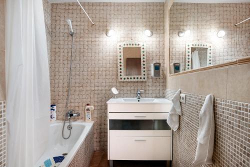 uma casa de banho com um lavatório, uma banheira e um chuveiro em Casa Chipiron em Vejer de la Frontera