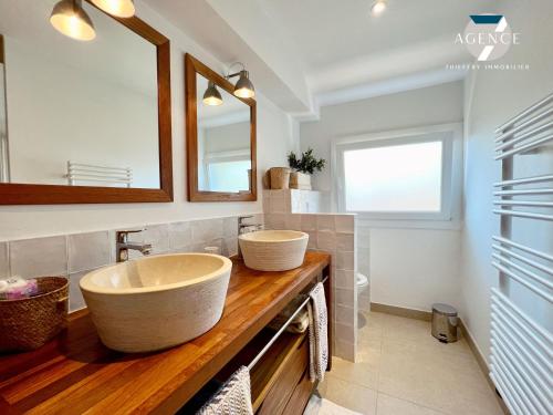 une salle de bain avec un grand lavabo et un miroir dans l'établissement Le Tropezien, à Grimaud