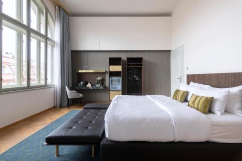 Un dormitorio con una cama grande y un banco. en numa I Laurel en Praga