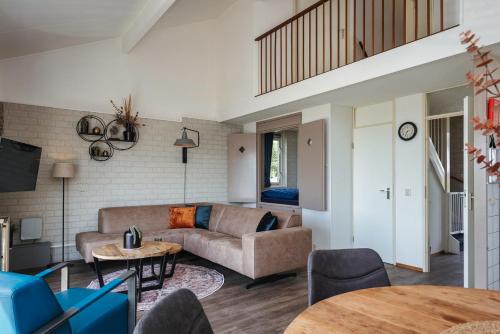 a living room with a couch and a table at Veluwe Strandbad Elburg in Elburg