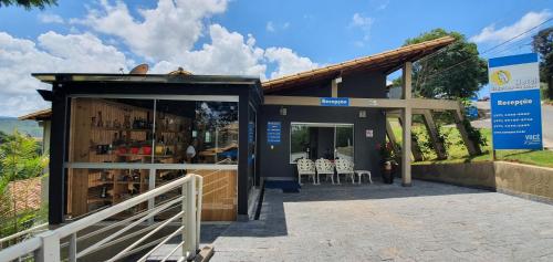 un edificio con una tienda con sillas. en Hotel Escarpas do Lago Capitolio en Capitólio