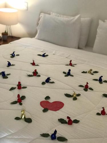 a white bed with a bunch of decorations on it at Pousada Vila Santa Maria in Pirenópolis