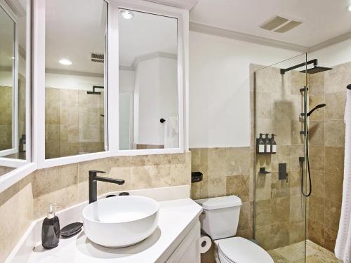 a bathroom with a sink and a toilet and a shower at Sago Garden Apartment at Royal Westmoreland in Saint James
