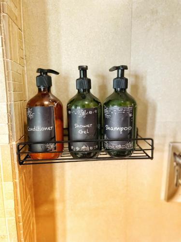 three bottles of soap on a shelf in a bathroom at Ochre Villa- Luxury property in Assagaon / Vagator in Vagator
