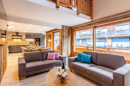 un salon avec deux canapés et une table dans l'établissement CHALET EAGLE, à Morzine