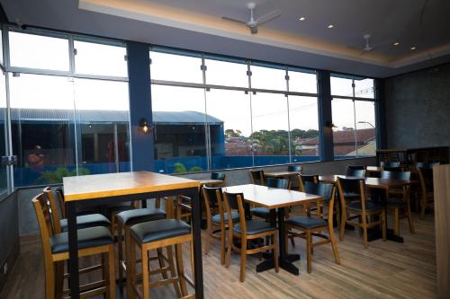 a restaurant with tables and chairs and large windows at Real Palace Hotel in Bebedouro