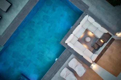 an overhead view of a pool with white furniture at Villa Belen in Kypseli