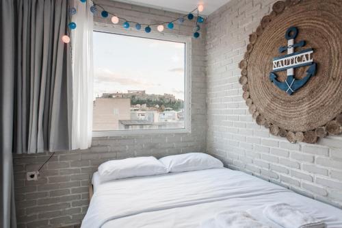 - une chambre avec un mur en briques et un lit avec une fenêtre dans l'établissement Wake up with Acropolis view!, à Athènes