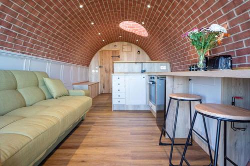 a living room with a couch and a brick wall at Mountain View in Llanfair Caereinion