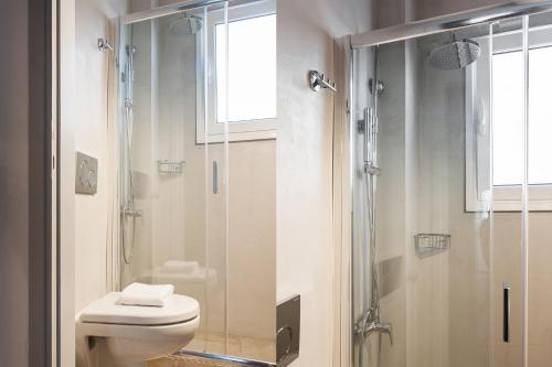 La salle de bains est pourvue de toilettes et d'une douche en verre. dans l'établissement Wake up with Acropolis view!, à Athènes