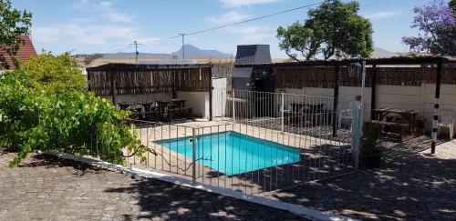 a fence around a swimming pool in a yard at Kelkiewyn Guesthouse Caledon in Caledon