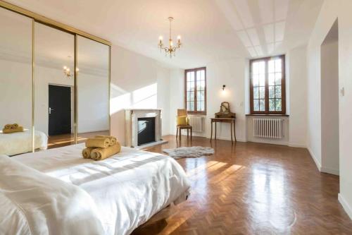 1 dormitorio blanco grande con 1 cama y chimenea en Domaine des Airs de Toscane, en Cazères