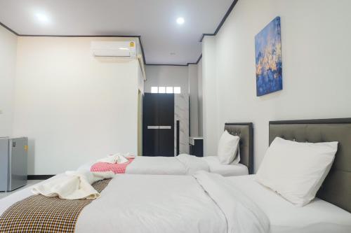 - 2 lits dans une chambre aux murs blancs dans l'établissement DD Grand Hotel, à Ban Na Ta Kai