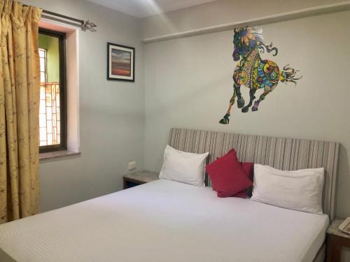 a bedroom with a bed with a horse on the wall at Remarkable 3-Bed Apartment in Panjim in Panaji