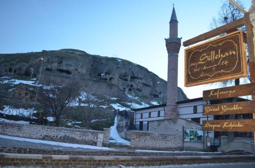 a mosque with a sign in front of a mountain at Sillehan Boutique Hotel in Konya