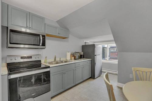 a kitchen with stainless steel appliances and a table at Suites on Seneca - Gorgeous One Bedroom Apartment in Harrisburg