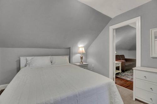 Un dormitorio con una cama blanca y un espejo. en Suites on Seneca - Gorgeous One Bedroom Apartment, en Harrisburg