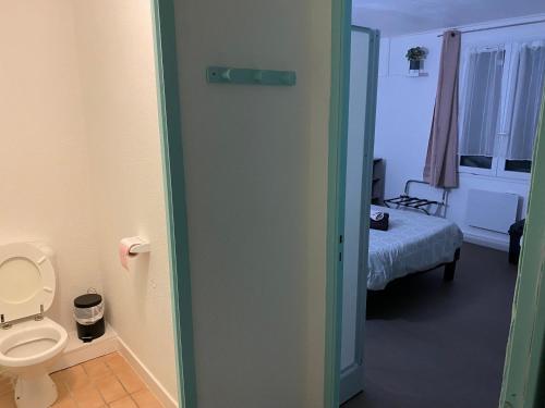 a bathroom with a toilet and a room with a bed at Résidence La Cigale du Désire Séjour chez l habitant in Riez