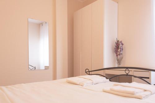 1 dormitorio con 1 cama con sábanas blancas y espejo en BnButler - Isonzo - Luminoso Appartamento in Porta Romana en Milán