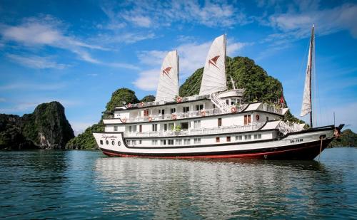 a boat on the water with mountains in the background at Signature Halong Cruise in Ha Long