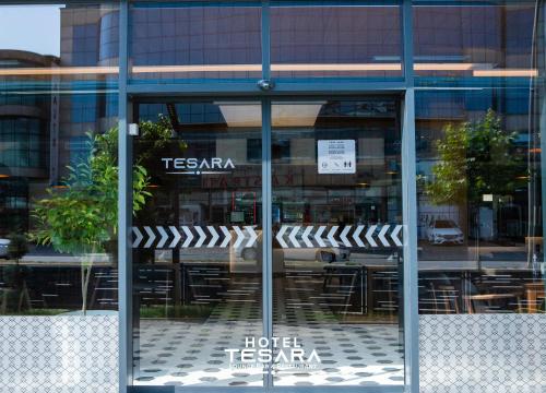 a glass window of a hotel with tables and chairs at Hotel Tesara in Prizren
