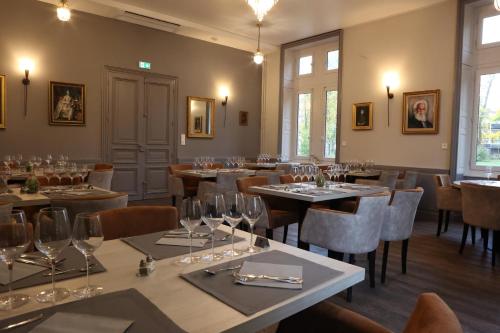 un restaurant avec des tables et des chaises et des verres à vin dans l'établissement Château de Petit Bois, à Cosne-dʼAllier