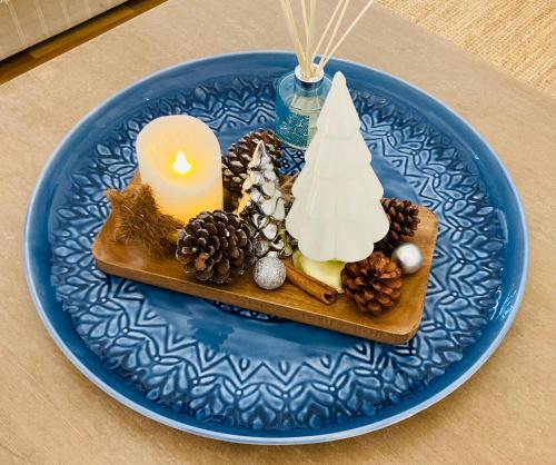 a blue plate with a candle and christmas decorations at Harbour Retreat Padstow - Entire Apartment in the beautiful old town of Padstow Harbour in Padstow