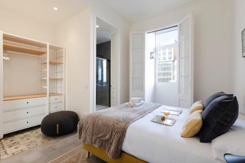 a white bedroom with a bed and a mirror at AB Centric Universitat in Barcelona