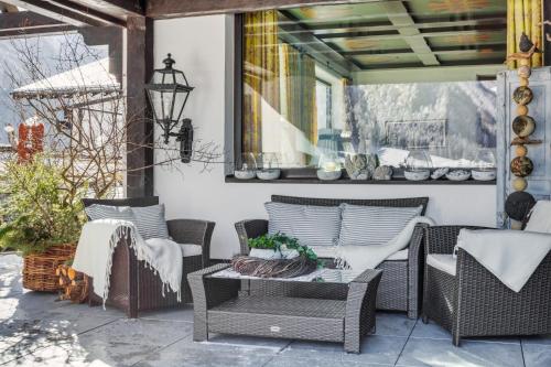 a patio with wicker chairs and a table at Das Lafairs in Pfunds