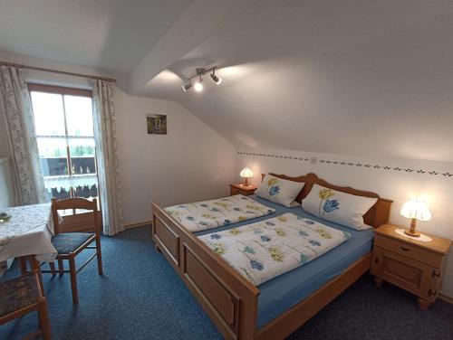 a bedroom with a bed and a table and a window at Landhaus Kamml in Anger