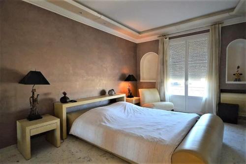 Un dormitorio con una gran cama blanca y una ventana en Palais Miramar Suite Art Modern - Derniere étages Vue Mer - 75m de confort - En Face des Plages -WIFI - Clim en Cannes